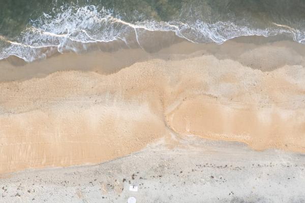 Top-down ariel view of waves coming onto Kitty Hawk beach