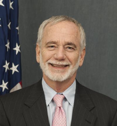 Headshot photo of William Yancey with the American flag in the background