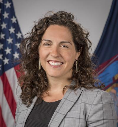 Headshot photo of Amanda Lefton with the American flag in the background