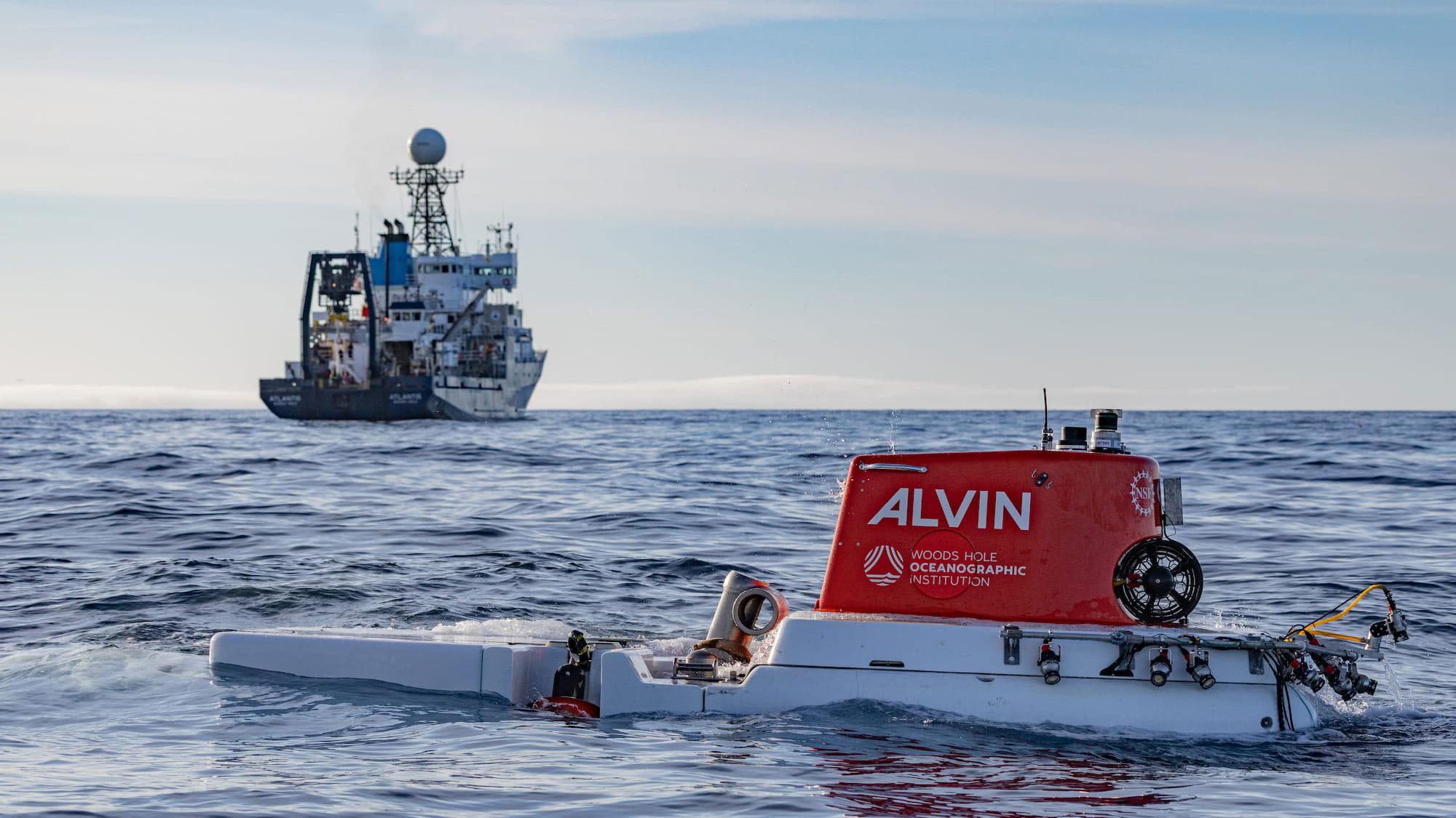  The U.S. Navy’s Human-Occupied Vehicle Alvin floats on the ocean, with the Research Vessel Atlantis in the background.