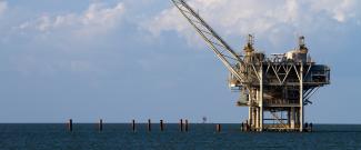 Gulf of Mexico oil rig against a cloudy blue sky