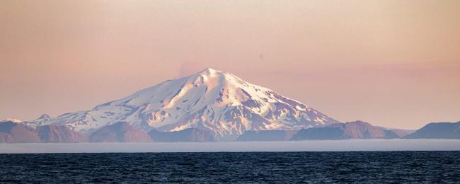 Volcanic island Great Sitkin rises from the ocean.