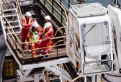 Industrial workers in a safety meeting on an offshore platform.