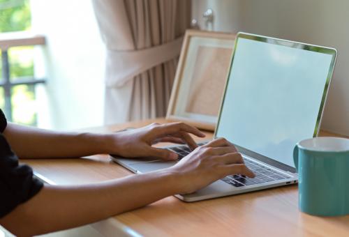 side view of woman working on a laptop computer