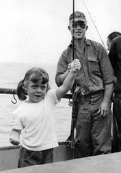 Early imprinting.  At 4 years, with a little help from dad, Ann catches her first rockfish out of the Point Loma Kelp Beds off San Diego. Her proud dad looks on.