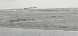 The Camille Cut filled in with fresh sand from the OCS,  with one of the dredges used in  the project floating in the distance. (Photo: F. Times, BOEM)