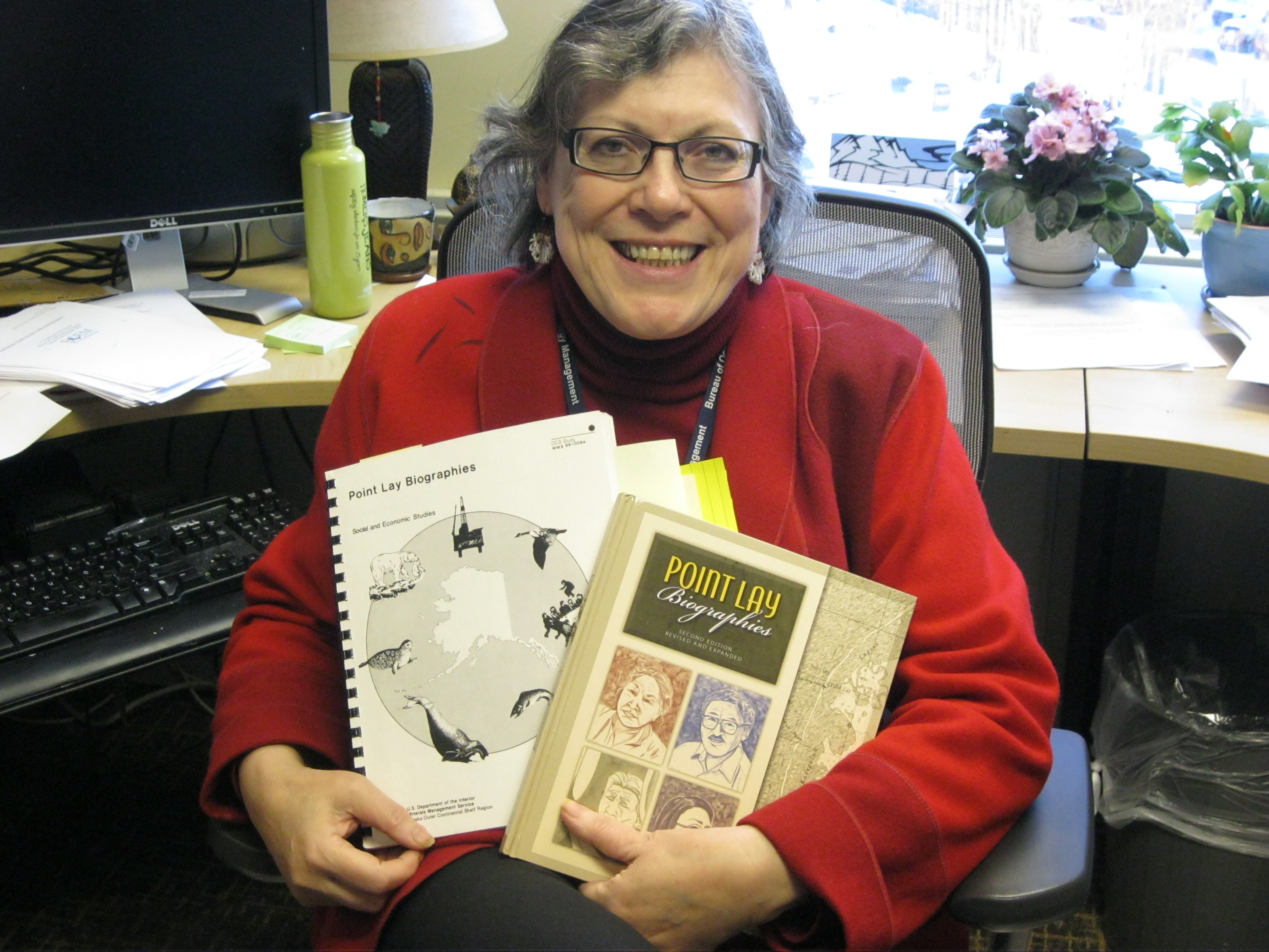 Chris Campbell holds copies of reports featured in article from The Arctic Sounder; BOEM photo